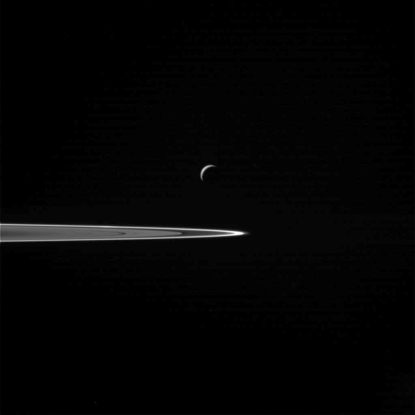 Enceladus seen before the flyby in front of Saturn's rings.